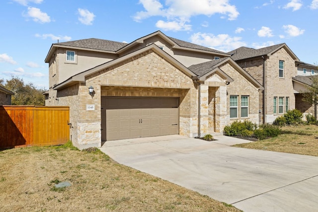 view of front of home with driveway, stone siding, fence, roof with shingles, and a garage