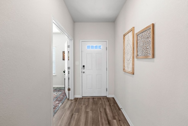 doorway to outside with baseboards and wood finished floors