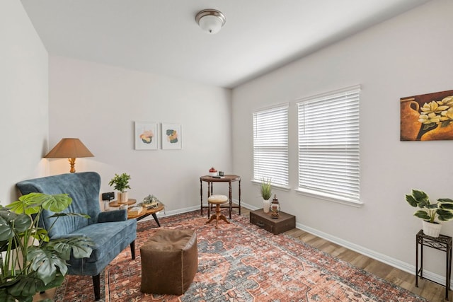 living area with baseboards and wood finished floors