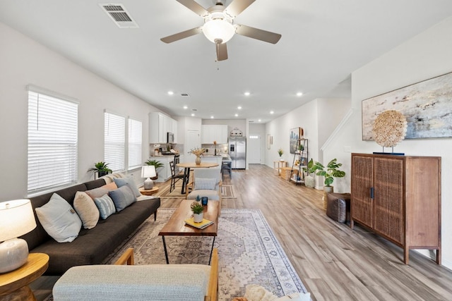 living area featuring recessed lighting, visible vents, light wood-style flooring, and a ceiling fan