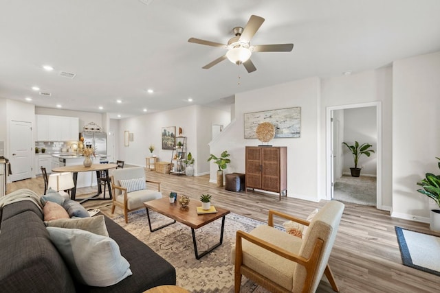 living area featuring light wood-type flooring, visible vents, recessed lighting, baseboards, and ceiling fan