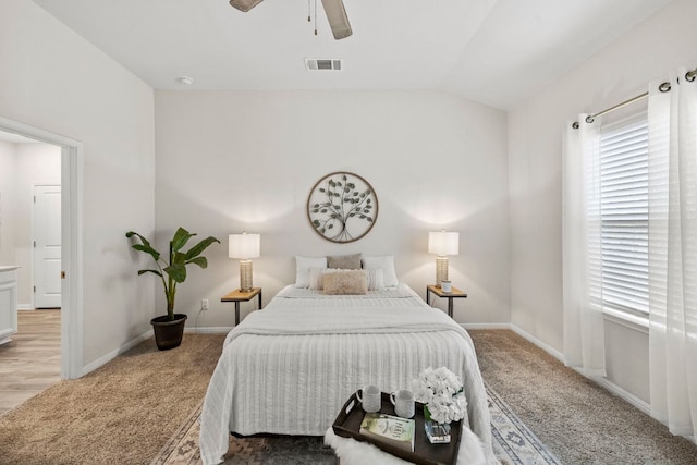 carpeted bedroom featuring lofted ceiling, baseboards, visible vents, and ceiling fan