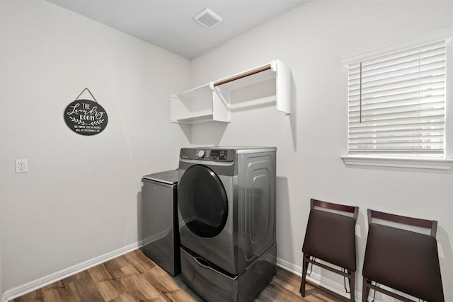 washroom featuring laundry area, baseboards, visible vents, and wood finished floors