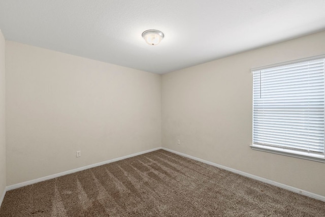 unfurnished room featuring carpet flooring and baseboards