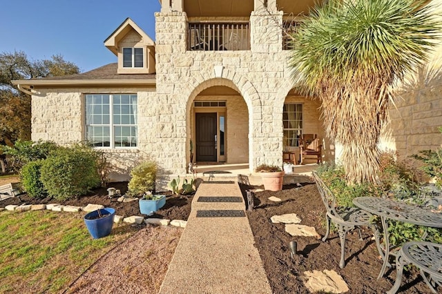 entrance to property featuring covered porch and stone siding