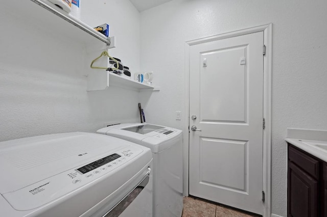 washroom featuring laundry area, light tile patterned floors, and washing machine and clothes dryer