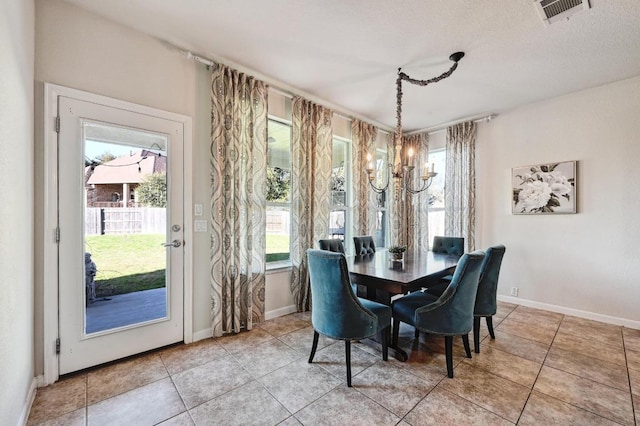 dining space with a notable chandelier, baseboards, visible vents, and light tile patterned floors