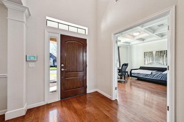 entrance foyer featuring visible vents, baseboards, beamed ceiling, hardwood / wood-style floors, and coffered ceiling