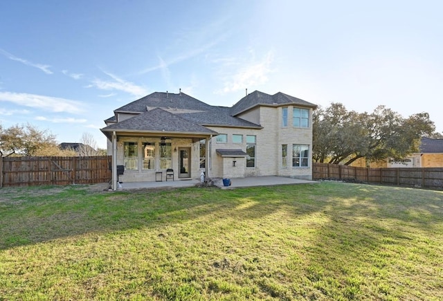 back of property with a patio, a lawn, a fenced backyard, and a ceiling fan