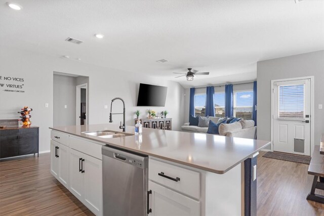 kitchen with wood finished floors, visible vents, ceiling fan, a sink, and stainless steel dishwasher