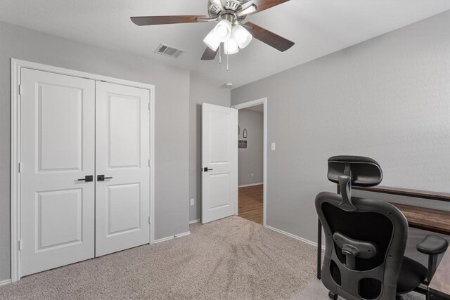 carpeted office space featuring visible vents, baseboards, and ceiling fan