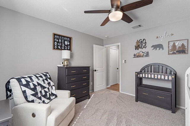 sitting room featuring visible vents, baseboards, a ceiling fan, and carpet floors