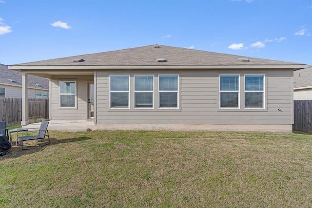 rear view of property with a patio, a lawn, and a fenced backyard