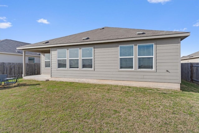 rear view of house featuring a lawn and fence private yard