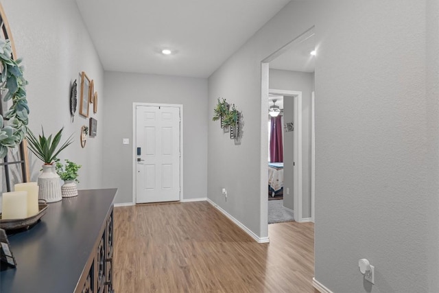 foyer featuring baseboards and light wood finished floors