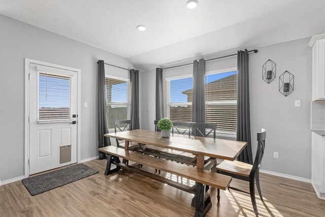 dining area featuring vaulted ceiling, recessed lighting, light wood-style floors, and baseboards