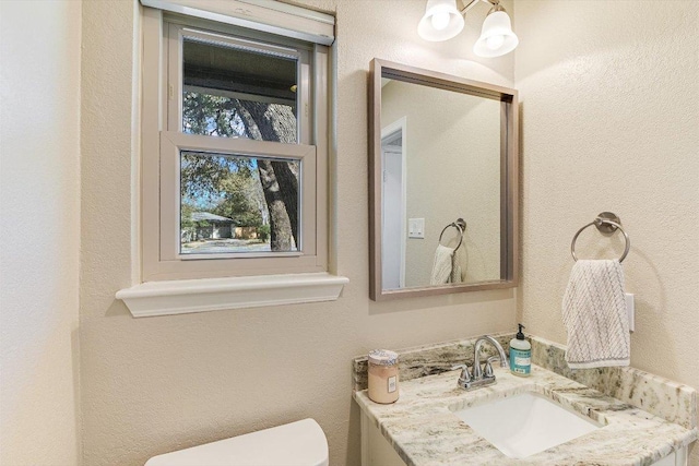 half bathroom with toilet and vanity