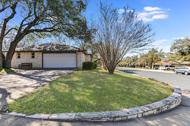 single story home with a front yard, a garage, stone siding, and driveway