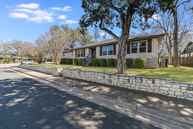 ranch-style house with fence and stone siding