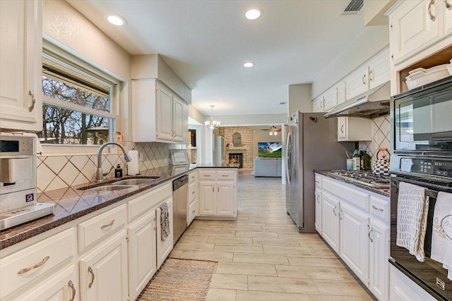 kitchen with visible vents, under cabinet range hood, appliances with stainless steel finishes, white cabinetry, and a sink