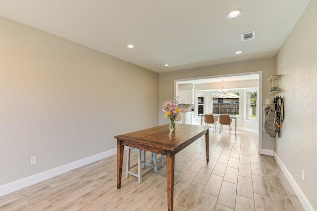 dining space featuring a chandelier, visible vents, light wood-type flooring, and baseboards