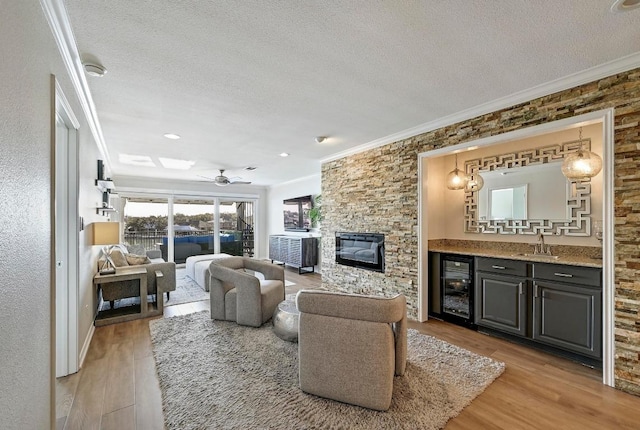 living room with a textured ceiling, beverage cooler, and ornamental molding