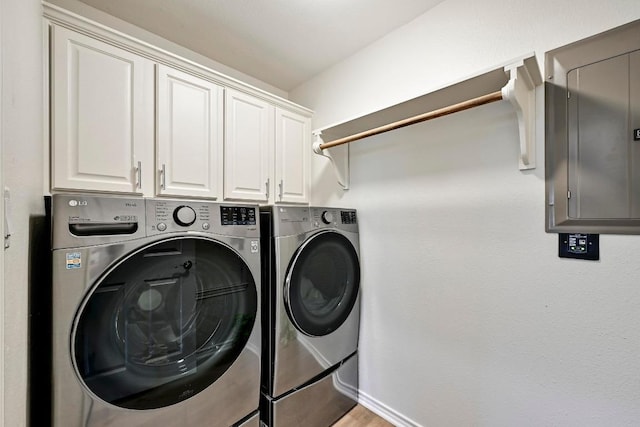 laundry room featuring cabinet space, washing machine and dryer, and electric panel