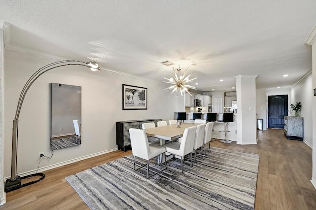 dining space with visible vents, ornamental molding, and wood finished floors