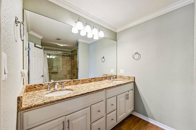 full bathroom with a sink, double vanity, tiled shower, and ornamental molding