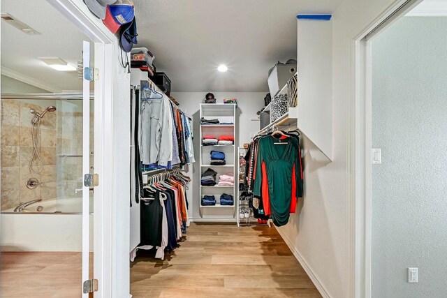 walk in closet with visible vents and wood finished floors