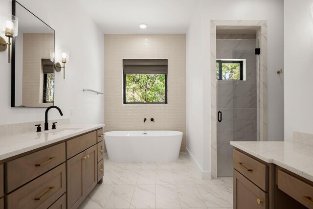 full bathroom with vanity, a soaking tub, marble finish floor, and a marble finish shower