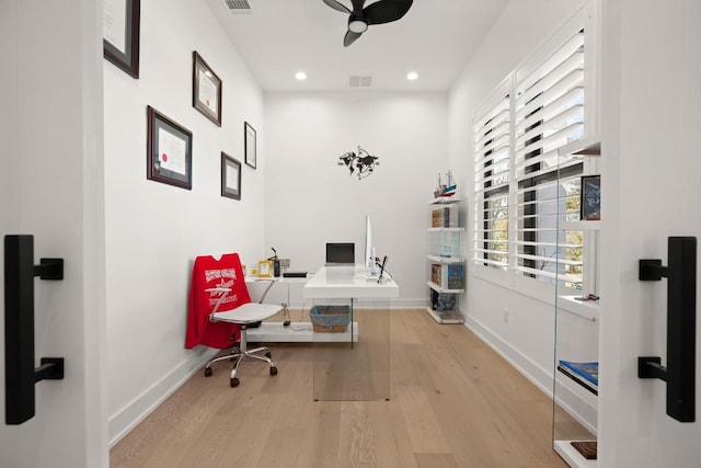 office space with a wealth of natural light, visible vents, ceiling fan, and wood finished floors