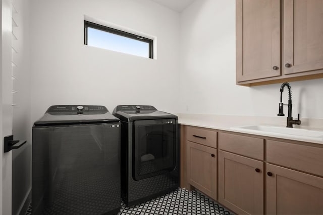 laundry area featuring washing machine and clothes dryer, cabinet space, and a sink