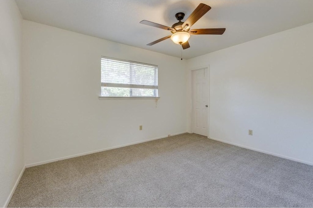 spare room featuring baseboards, light carpet, and ceiling fan