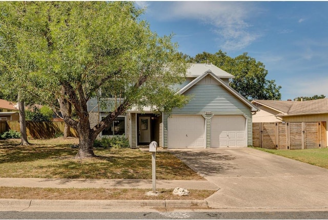 view of front facade with fence, a garage, and driveway