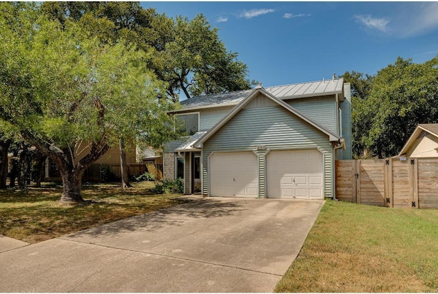 traditional-style home with a front yard, a gate, fence, driveway, and a garage