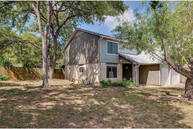 view of front facade featuring metal roof, a front yard, a garage, and fence