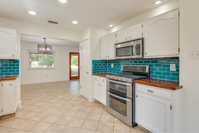 kitchen featuring dark countertops, visible vents, white cabinets, and stainless steel appliances