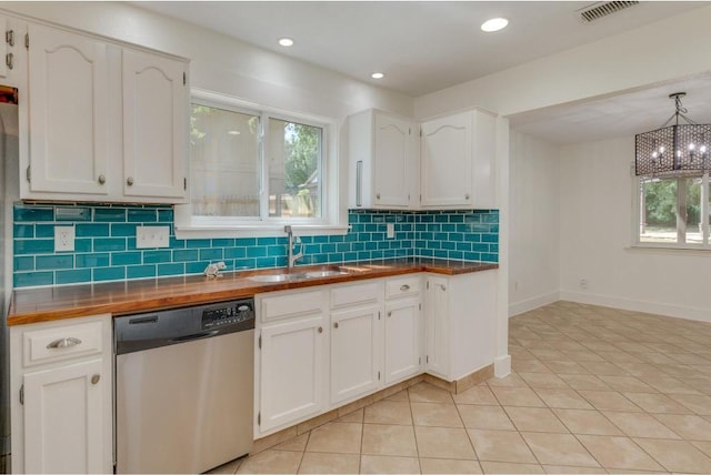 kitchen featuring visible vents, dishwasher, light tile patterned flooring, white cabinets, and a sink