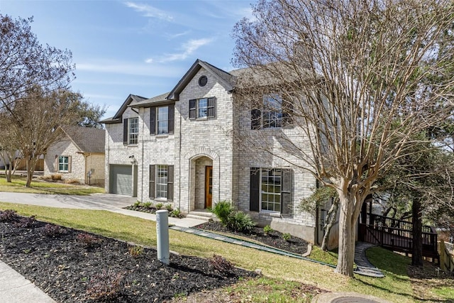 view of front of house with brick siding, a front lawn, an attached garage, and driveway