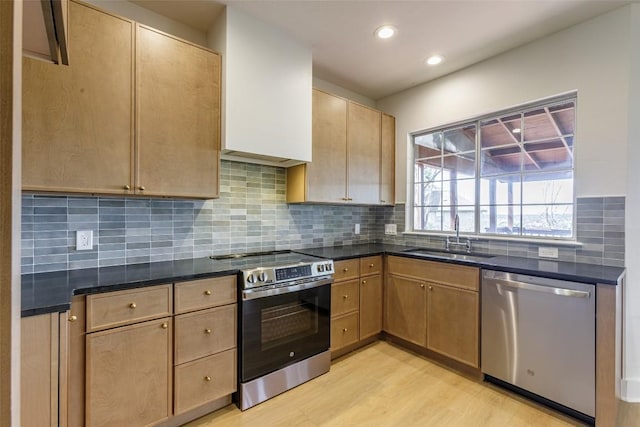 kitchen featuring recessed lighting, a sink, decorative backsplash, stainless steel appliances, and light wood-type flooring