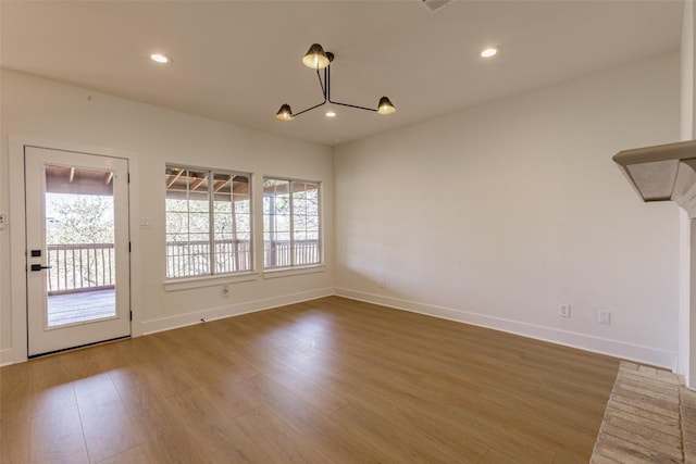 unfurnished dining area featuring recessed lighting, a healthy amount of sunlight, and wood finished floors