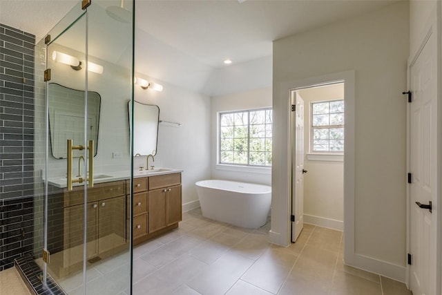 bathroom with a sink, double vanity, a shower stall, and a freestanding bath