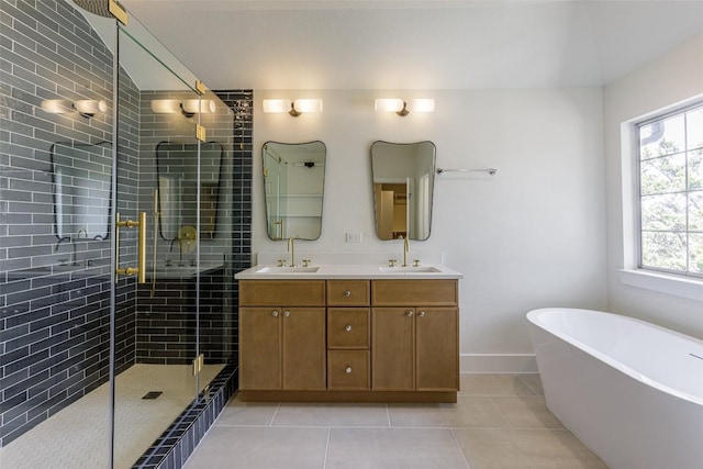 full bathroom featuring a shower stall, double vanity, tile patterned floors, a soaking tub, and a sink