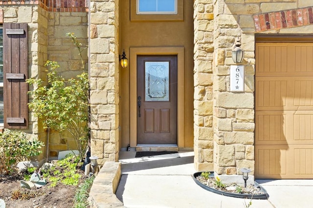 property entrance featuring stucco siding and stone siding