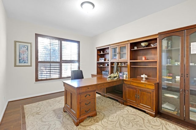 office area featuring baseboards and light wood-style flooring