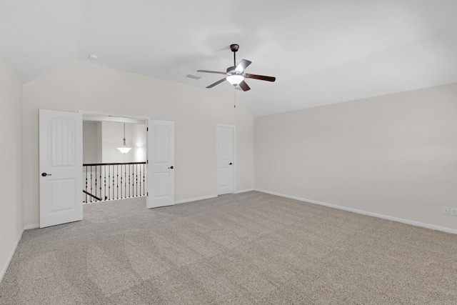 interior space featuring carpet, visible vents, baseboards, lofted ceiling, and ceiling fan