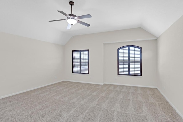 unfurnished room featuring ceiling fan, vaulted ceiling, baseboards, and light carpet