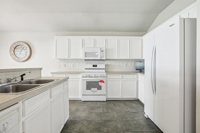 kitchen featuring white appliances, white cabinets, and a sink