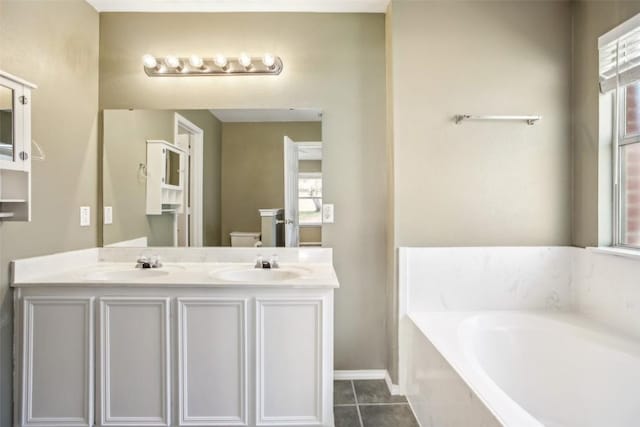 bathroom featuring a sink, toilet, a bath, and tile patterned floors